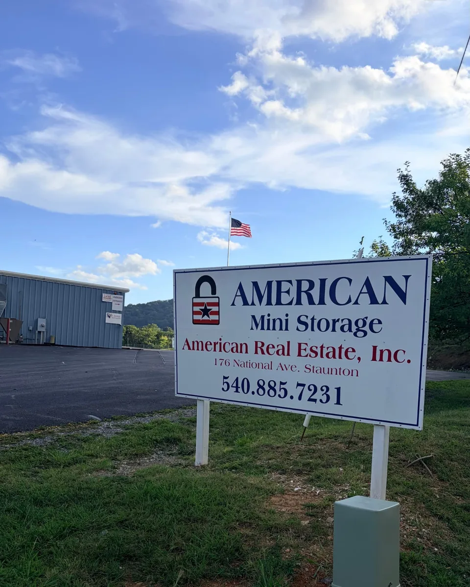 American Mini Storage roadside sign at 176 National Ave, Staunton VA, with the rental office and American flag behind it